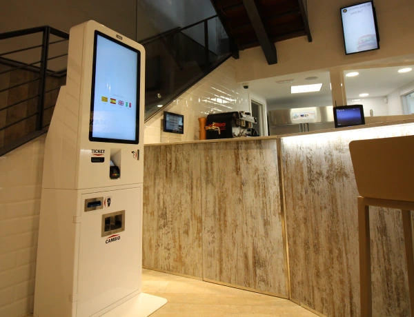 Cliente pagando en efectivo en un quiosco T-Quiosk
